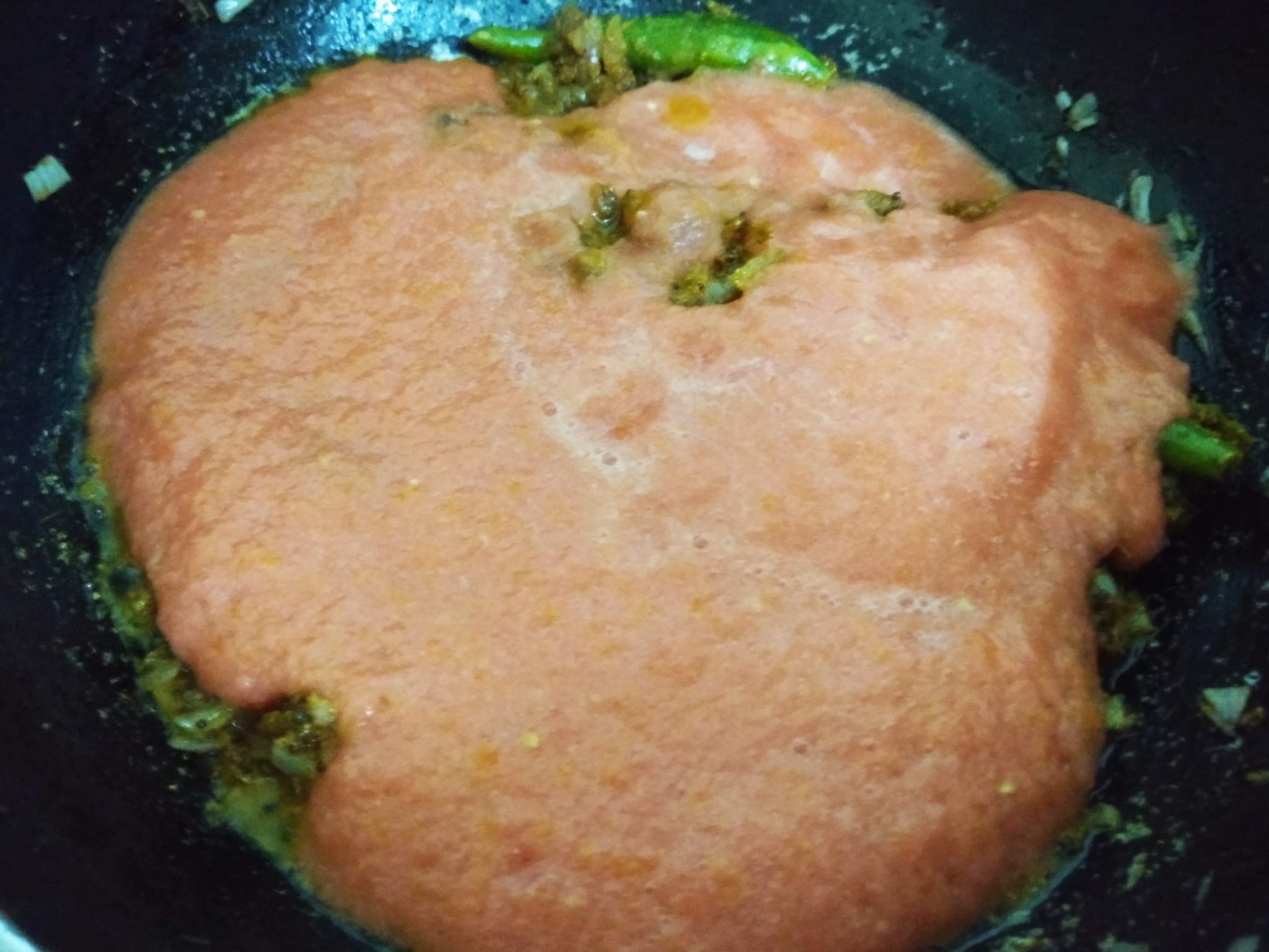 Add tomato puree to the pan