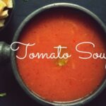 Easy and Homemade Tomato soup served with croutons and fresh basil or cilantro leaves