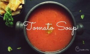 Easy and Homemade Tomato soup served with croutons and fresh basil or cilantro leaves