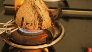 hold the coconut shell on flame with help of a holder